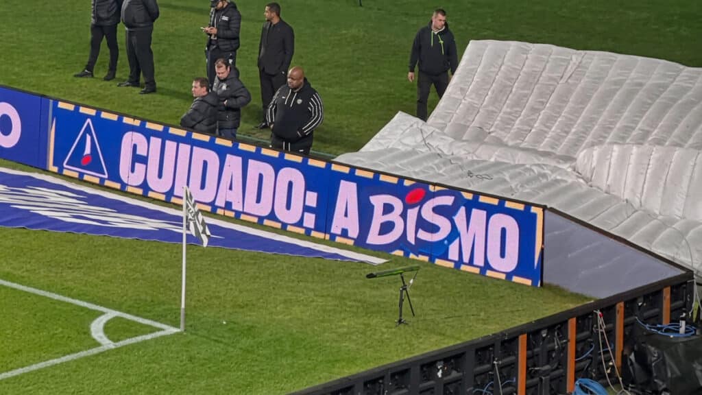 Placa no campo com mensagem “CUIDADO: A BISMO” em ação do BIS no túnel do Couto Pereira após queda de jogador.