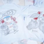 Camisas de coleção Red Bull e FURIA na cor branca com ilustrações e texto do mapa exclusivo de CS2.