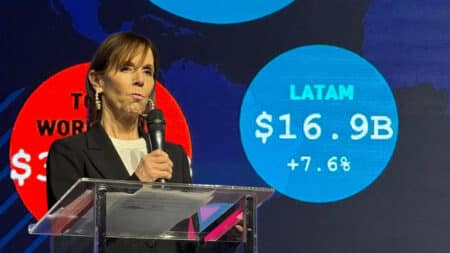 Licensing Con LATAM 2026: Brasil lidera crescimento na América Latina Palestrante em evento com telão mostrando LATAM US$ 16.9B e +7.6% ao lado do cenário