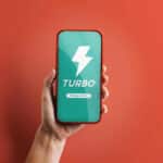 Celular em mão exibindo o app Shopee Turbo, serviço de entrega rápida para pedidos.