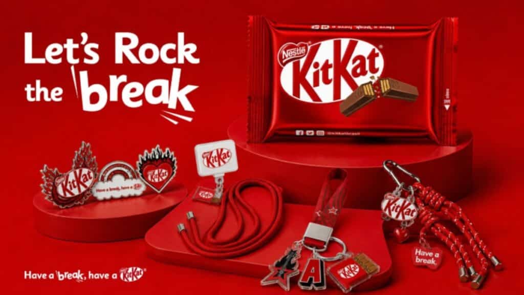 KitKat com brinde do Rock in Rio: embalagem vermelha, cordão, chaveiro e outros acessórios na bancada
