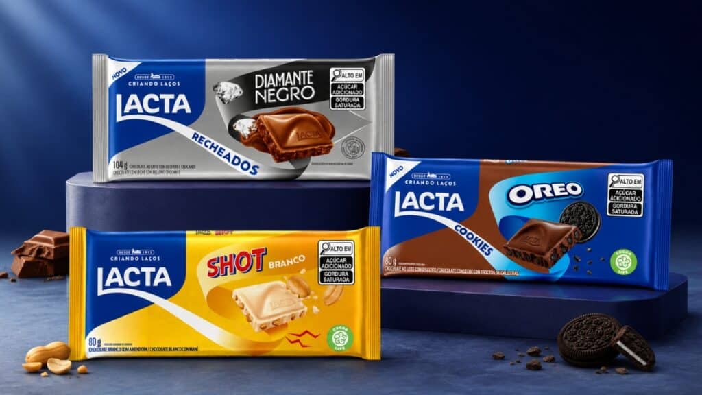 Embalagens de chocolates Lacta e Oreo na foto, com barras e tabletes sobre fundo azul.