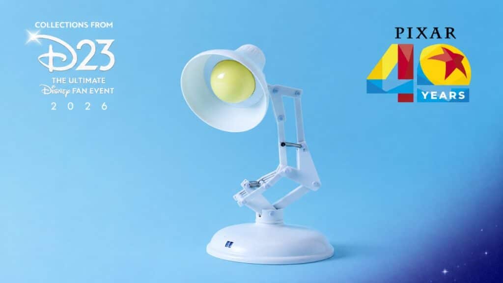 Luminária interativa Luxo Jr. branca com olhos amarelos em fundo azul, com logotipos “D23” e “Pixar 40 Years”.