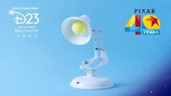 Luminária interativa Luxo Jr. 40 anos Pixar (D23) Luminária interativa Luxo Jr. branca com olhos amarelos em fundo azul, com logotipos “D23” e “Pixar 40 Years”.