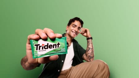 Maluma na campanha Trident “Que Se Masque” Maluma em campanha da Trident, segurando embalagem verde de goma de mascar em fundo verde