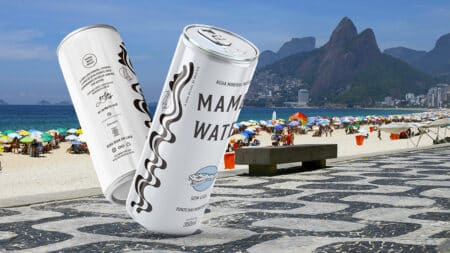 Mamba-rio: lata comemorativa na Orla Rio Lata de água Mamba-rio em destaque na orla do Rio de Janeiro, com quiosques e montanhas ao fundo.