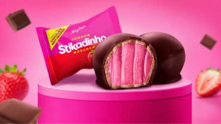 Bombom Stikadinho Neugebauer em novo formato Bombom Stikadinho da Neugebauer com recheio rosa em destaque e embalagem ao fundo
