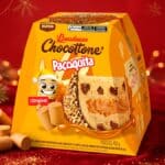 Chocottone Paçoquita Bauducco em embalagem amarela sobre fundo vermelho de Natal, com farofa e biscoitos ao redor.