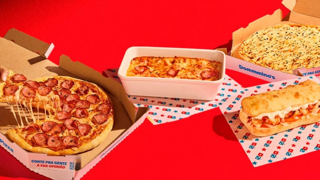 Promoção Domino’s com pizzas e lasanha Promoção da Domino’s com pizzas e lasanha em caixas, fundo vermelho