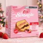 Embalagem do Panettone Nestlé Sensação com recheio duplo de morango e chocolate, ao lado de frutas e enfeites de Natal.