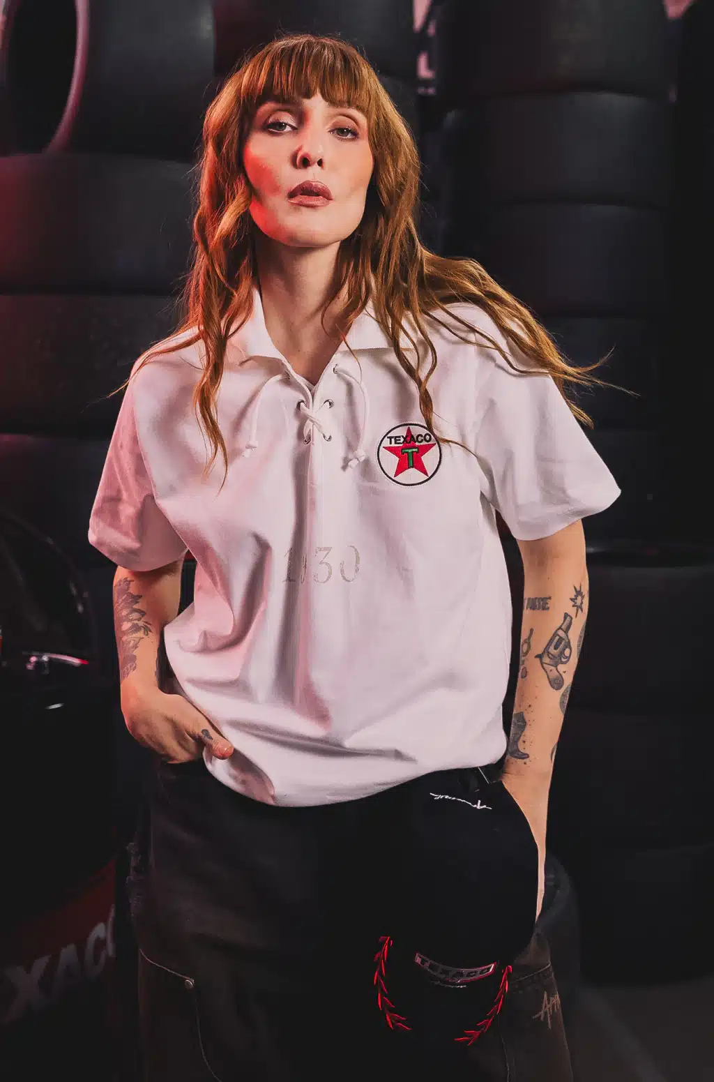 Modelo usa camisa branca da Texaco com patch “T”, em parceria com a Approve, em foto de divulgação de coleção