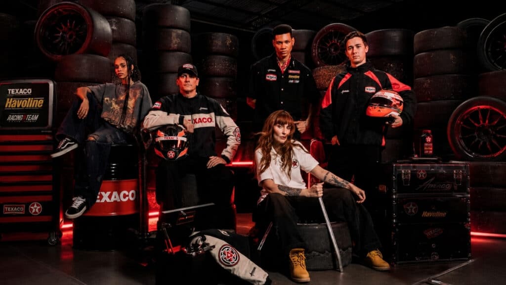 Campanha da Texaco com a marca Approve, modelo em estúdio com roupas streetwear e cenário automotivo ao fundo.