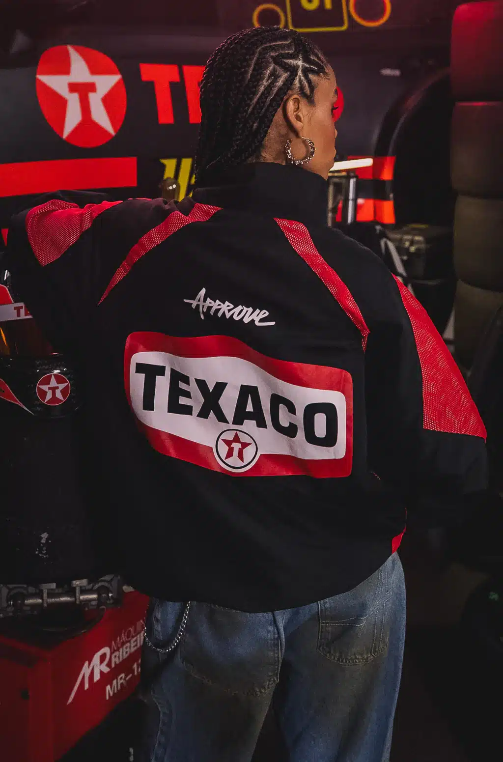 Modelo vestindo jaqueta preta da coleção Texaco x Approve, com patch “TEXACO” em destaque