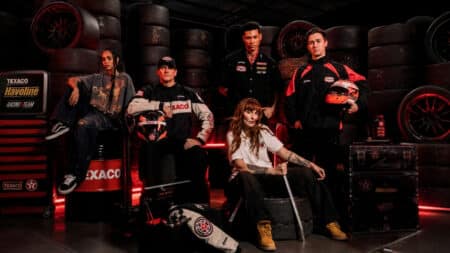Texaco e Approve lançam coleção streetwear Campanha da Texaco com a marca Approve, modelo em estúdio com roupas streetwear e cenário automotivo ao fundo.