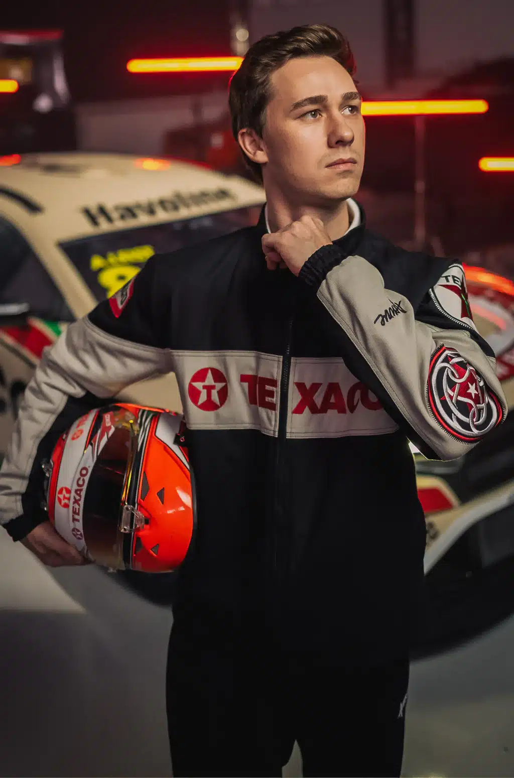 Modelo posando em estande, usando jaqueta bomber da Texaco em parceria com a Approve.