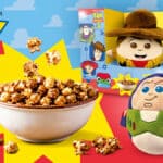 Embalagem do Cacau Show com Pipoca Toy Story e pelúcias do Buzz e do Woody ao lado.