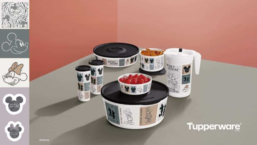 Tupperware Disney Mickey e Minnie Mouse Conjunto de produtos Tupperware com estampas de Mickey e Minnie Mouse, sobre mesa, em fundo rosa.