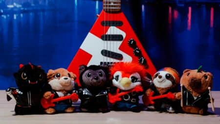 Pelúcias colecionáveis do Venancio no Rock in Rio Pelúcias colecionáveis fantasiadas em frente a um letreiro com a marca do Venancio no Rock in Rio