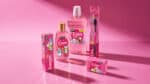 Linha de produtos de higiene Even com personagens BT21 em embalagens rosa, vidro e tubos sobre fundo rosado