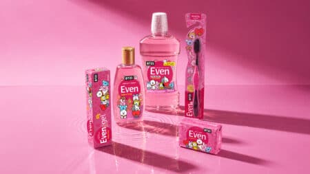 Even x BT21: coleção de higiene bucal e pessoal Linha de produtos de higiene Even com personagens BT21 em embalagens rosa, vidro e tubos sobre fundo rosado