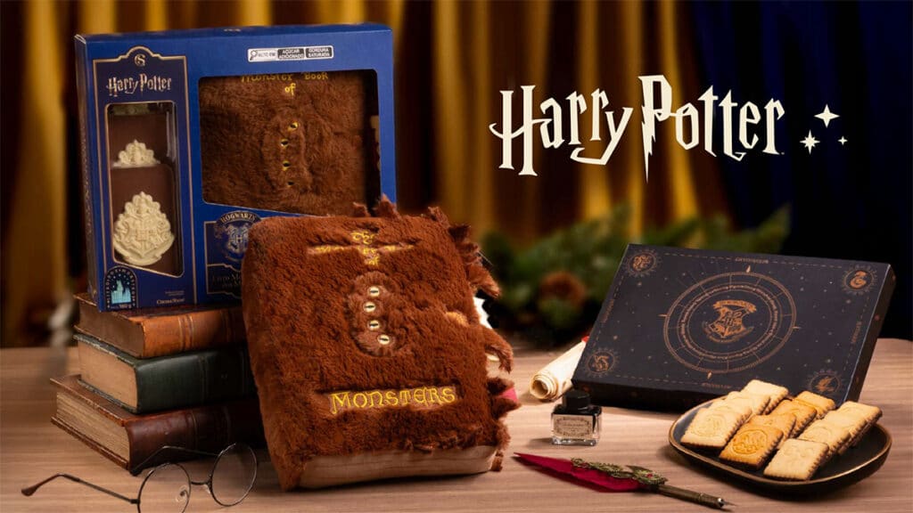 Embalagem e pelúcia interativa do Livro dos Monstros de Harry Potter em cenário de Natal da Cacau Show.