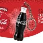 Imagem de mini chaveiro em formato de garrafa Coca-Cola, com ilustração de promoção “Coca-Cola Classics”.