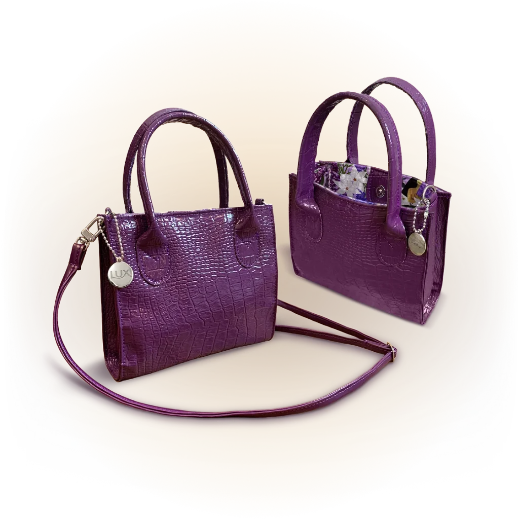 Duas bolsas pequenas roxas com alças e alça de mão, modelo assinado pela Carol Burgo na promoção Lux