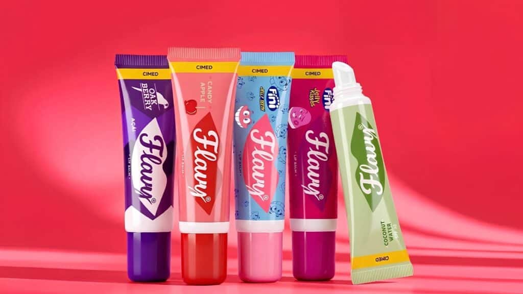 Flavy Cimed: produtos em tubos coloridos anunciando Portugal Embalagens de beleza Flavy da Cimed em tubos coloridos sobre fundo vermelho, anunciando expansão internacional para Portugal.