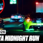 Carros de corrida com luzes neon na pista em noite, com placas “FUJI 2026” e “TOYOTA MIDNIGHT RUN”.