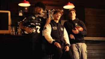 Jack Daniel’s x NFL: cena em bar com coleção Homens usando jaquetas e acessórios em um bar, com garrafa ao fundo e referência à parceria Jack Daniel’s e NFL.