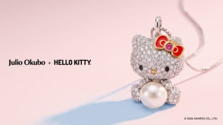 Julio Okubo + Hello Kitty: pingente com pérola e zircônias Pingente Hello Kitty em joalheria Julio Okubo + Hello Kitty, com colar de pérolas e brilho de zircônias em fundo rosa