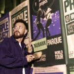 Homem em palco segurando papel ao lado de banners com a marca Nubank Parque, durante evento do Purple Project World Tour.