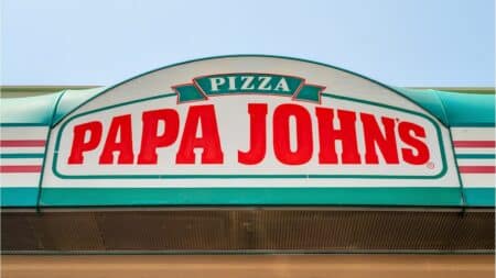 Papa Johns Brasil: letreiro na fachada Fachada da loja com o letreiro “PAPA JOHNS” e o nome PIZZA em destaque.