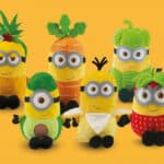 Pelúcias colecionáveis dos Minions em formato de frutas e legumes, em fundo amarelo