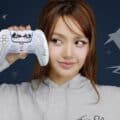 Lisa do BLACKPINK segura um controle DualSense da PlayStation em fundo azul com estrelas e formas