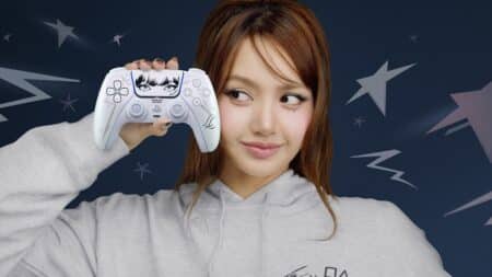 Lisa do BLACKPINK segura um controle DualSense da PlayStation em fundo azul com estrelas e formas