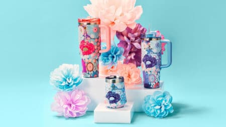 Stanley Spring Collection com copos e flores decorativas Coleção Stanley Spring Collection com copos térmicos estampados e flores decorativas em fundo azul claro