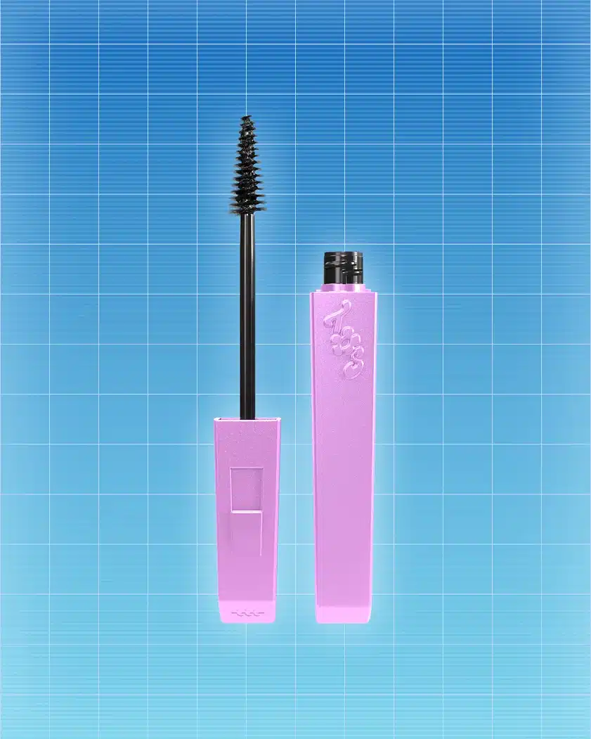 Máscara de cílios e frasco de maquiagem em tons rosa e preto, com fundo de azulejos azul, da linha Três Espiãs Demais da Martine Cosmetics.