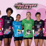 Seis jogadoras do vôlei usando camisas da coleção Meninas Superpoderosas da CBV, em fundo rosa com logos do Vôlei Brasil.
