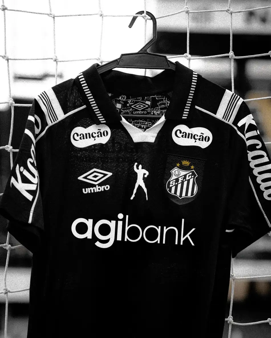Camisa do Santos com a marca agibank, pendurada em rede de treino