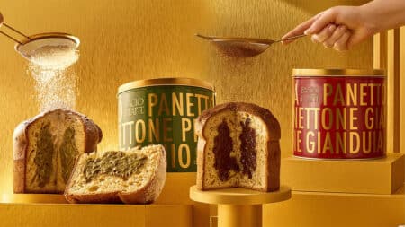 Panettone Bacio di Latte Pistacchio e Gianduia Potes e fatias de panettone Bacio di Latte com embalagens de Pistacchio e Gianduia em fundo dourado