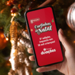 Celular com anúncio da 5ª edição “Cartinhas de Natal” da Shopee Doações durante clima de Natal.