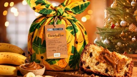 Panetoffe da Nanica com doce de leite de banana no Natal Panetoffe da Nanica em embalagem decorada, com fatia de panetone e doce de leite de banana ao lado de frutas e decoração natalina