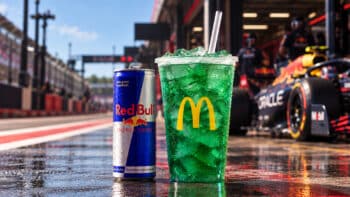 McDonald’s e Red Bull: bebida exclusiva em copo com gelo Copo com bebida verde e gelo da parceria McDonald’s e Red Bull ao lado de lata Red Bull em ambiente externo