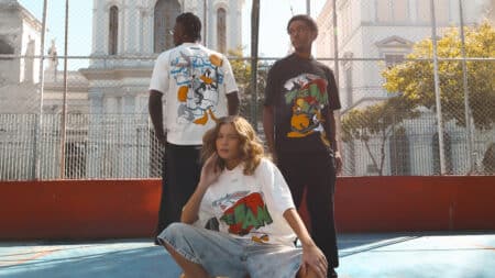 Kings Sneakers Space Jam com Warner Coleção Space Jam da Kings Sneakers: pessoas usando camisetas com personagens e paleta do filme, em cena ao ar livre.