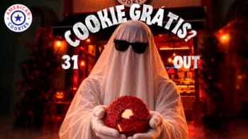 American Cookies Halloween: cookie gratuito com fantasia Pessoa fantasiada de Halloween com gorro segurando um cookie vermelho, em frente a letreiro “Cookie Gratis?” e data 31.