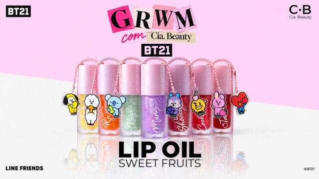 Cia Beauty BT21 Lip Oil Sweet Fruits com frascos rosa, roxos e charms colecionáveis ao fundo rosa