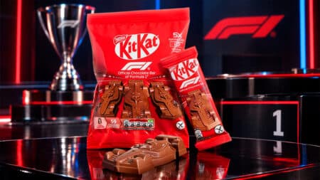 KitKat com carrinhos de chocolate inspirados na F1 Embalagem vermelha da KitKat com carrinhos de chocolate inspirados na F1, em cenário de corrida