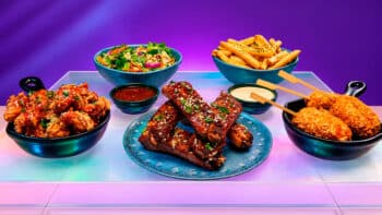 Outbac-K: cardápio sul-coreano do Outback com pratos e molhos Mesa com pratos do Outbac-K inspirado na culinária sul-coreana, com frango, bolinhas apimentadas e batatas fritas.