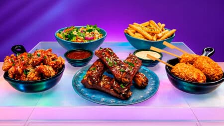 Outbac-K: cardápio sul-coreano do Outback com pratos e molhos Mesa com pratos do Outbac-K inspirado na culinária sul-coreana, com frango, bolinhas apimentadas e batatas fritas.